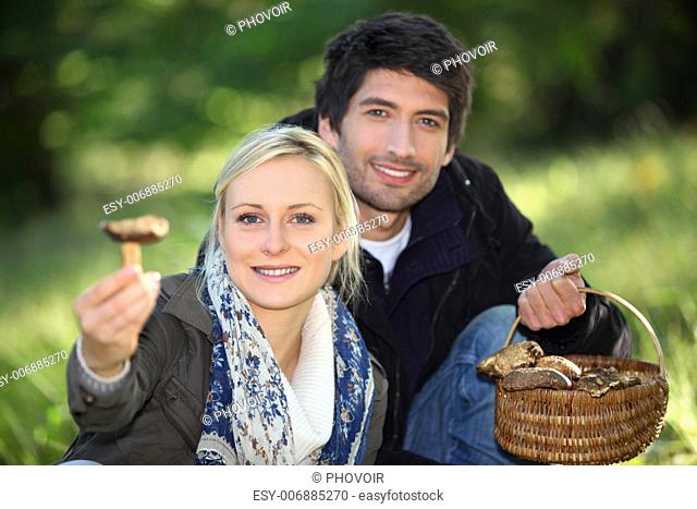 Couple picking mushrooms in a forest