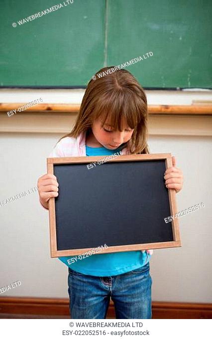 Portrait of a girl looking at a school slate