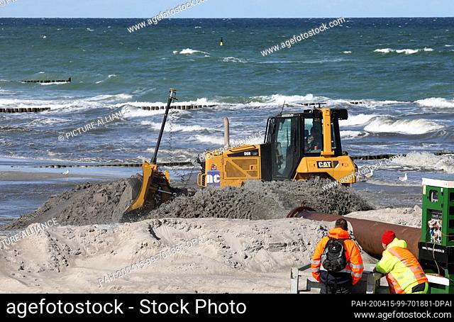 14 April 2020, Mecklenburg-Western Pomerania, Graal-Müritz: On the Baltic Sea beach the planned washing up has begun, a bulldozer distributes the washed up sand