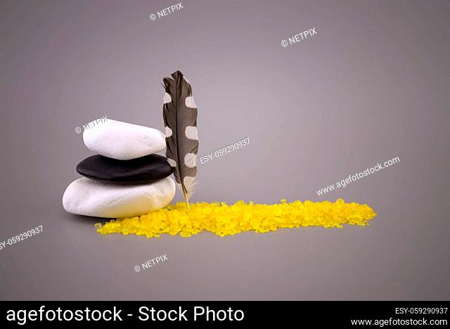 Stack of black and white stones and woodpecker feather, zen still life with calm shades of gray, black and white, free copy space for text