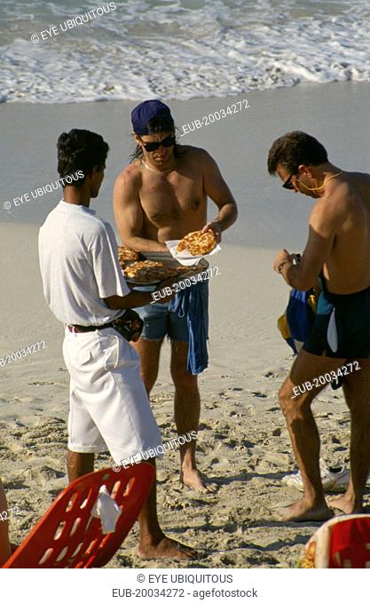 Man selling pizza to tourists on the beach