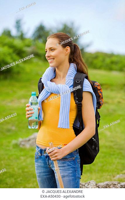 Young woman hiking and drinking water