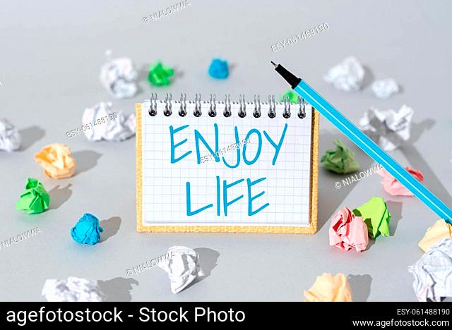 Conceptual caption Enjoy Life, Word for Any thing, place, food or person, that makes you relax and happy Important Message Presented On Notepad With Paperwraps...
