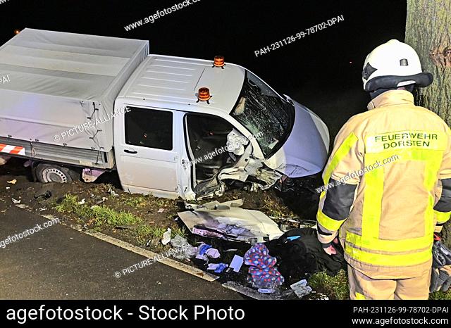 26 November 2023, North Rhine-Westphalia, Dorsten: A firefighter looks at the van involved in the accident. Because a drunk driver crashed his van into a tree