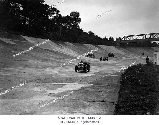 Cars racing on the Members Banking at a JCC Members Day, Brooklands. Artist: Bill Brunell