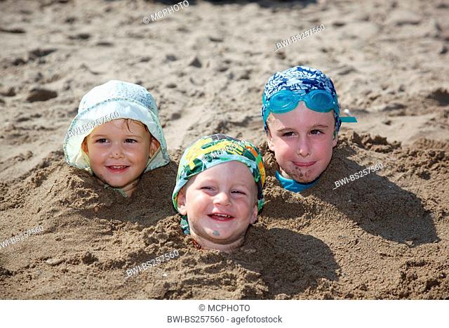 three children dug in sand