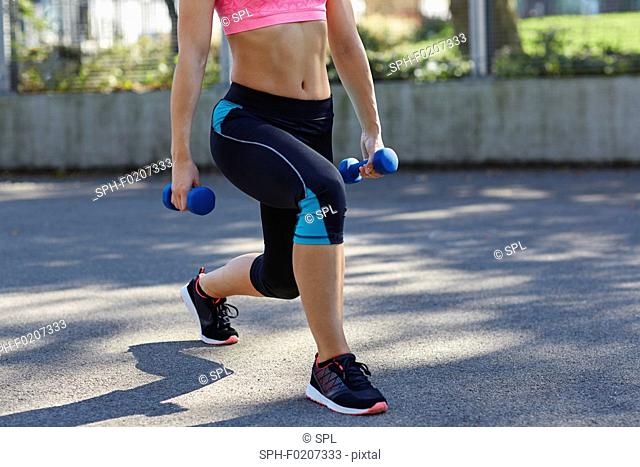 Young woman using hand weights