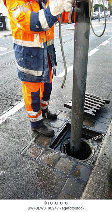 worker of public services cleaning storm drain, Germany