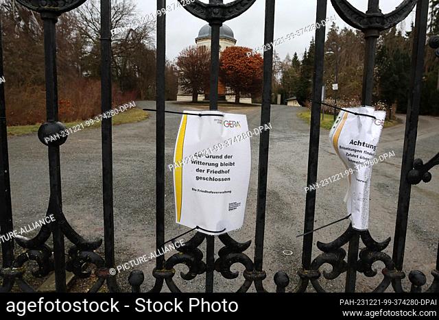 21 December 2023, Thuringia, Gera: A sign announcing the closure of the municipal cemetery due to storm ""Zoltan"" hangs at the closed entrance gate