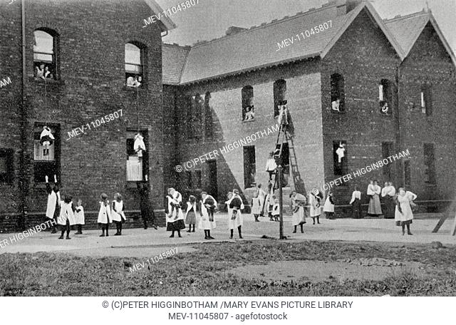 A fire drill at Headingley Orphan Homes, Leeds. Children evacuate upper floor via ladders and ropes