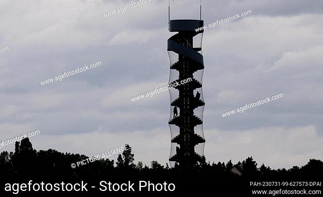 31 July 2023, Saxony-Anhalt, Bitterfeld-Wolfen: Tourists climb the 26-meter-high water level tower in Lake Goitzsee near Bitterfeld-Wolfen
