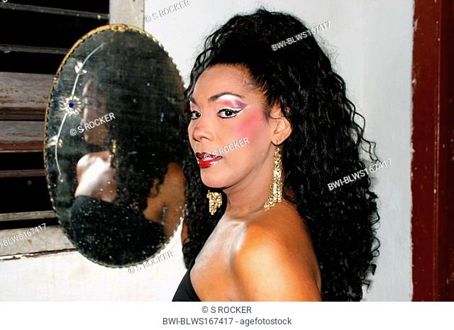 transvestite with long black hair in front of a mirror in an apartment, Cuba, La Habana