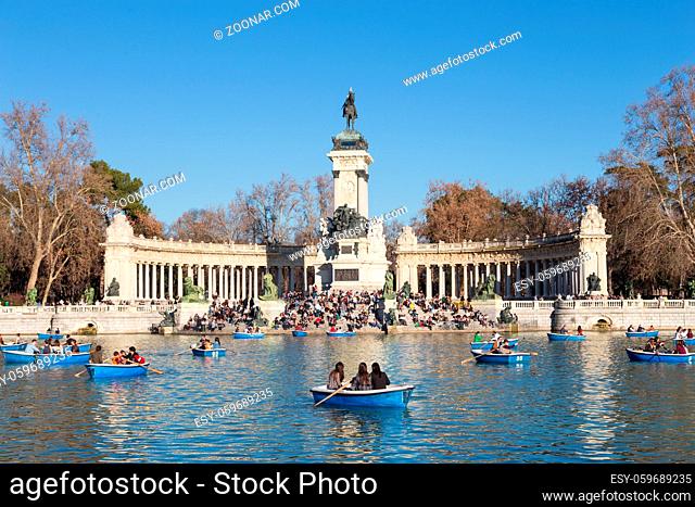 Madrid, Spain - Jan 24, 2016: Tourists rowing traditional blue boats on lake in Retiro city park on a nice sunny winter day on January the 24th in Madrid, Spain