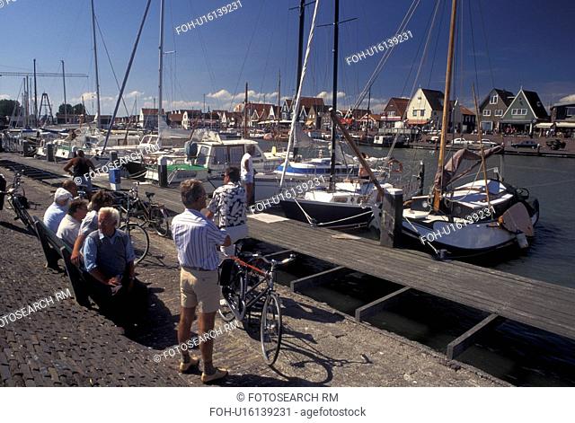 Holland, Volendam, Netherlands, Noord-Holland, Europe, People relaxing on the waterfront on the harbor on Markermeer in the town of Volendam