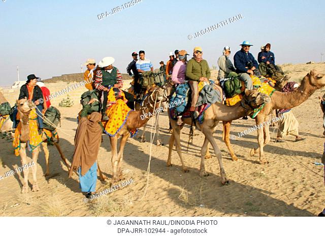 Camel ride at Sam Thar desert safari sand dunes , Jaisalmer , Rajasthan , India