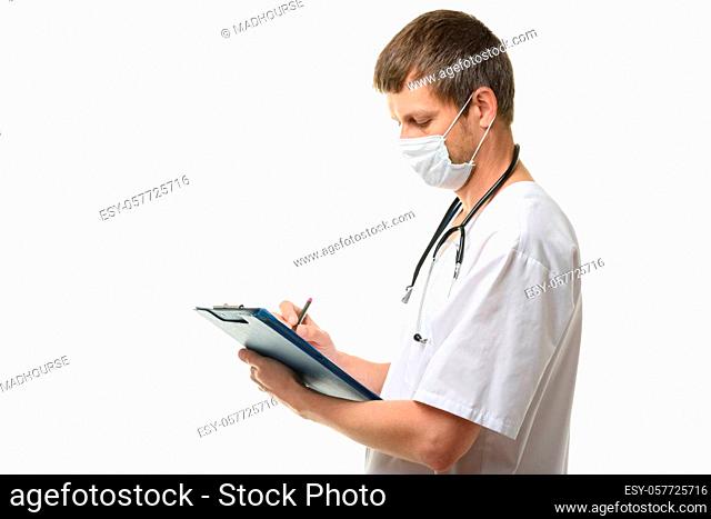 Male doctor writes in a clipboard with a ballpoint pen