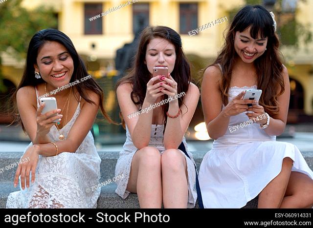 Portrait of three multi ethnic young beautiful women as friends together at the park outdoors