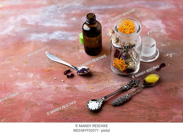 Blossoms of medical plants, medicine flasks, marigold salve and globules
