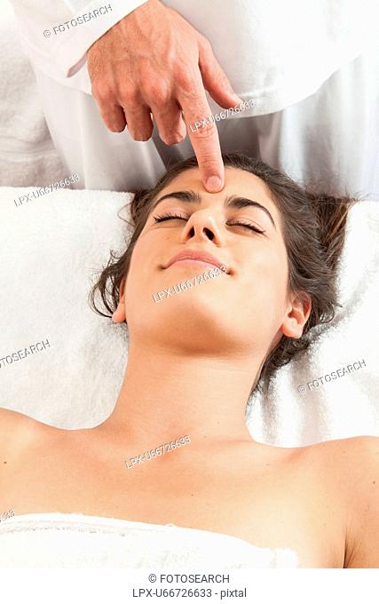 Relaxed woman gets a massage on her head