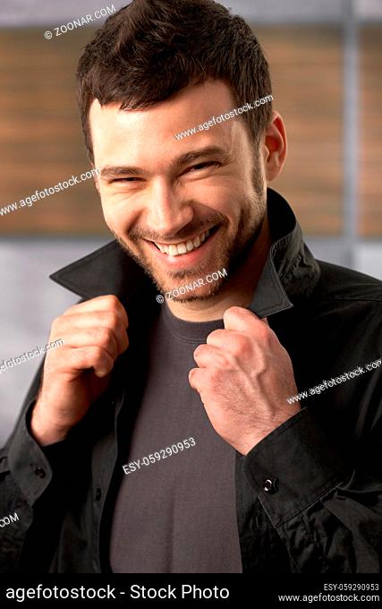 Trendy young man laughing at camera posing in stylish shirt