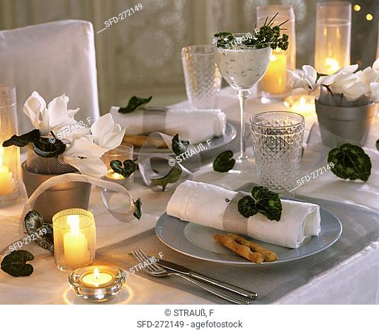 Table laid in silver and white with Cyclamen and herb dip