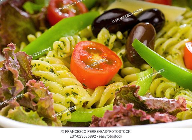 fresh healthy homemade italian fusilli pasta salad with parmesan cheese, pachino cherry tomatoes, black olives and mix vegetables