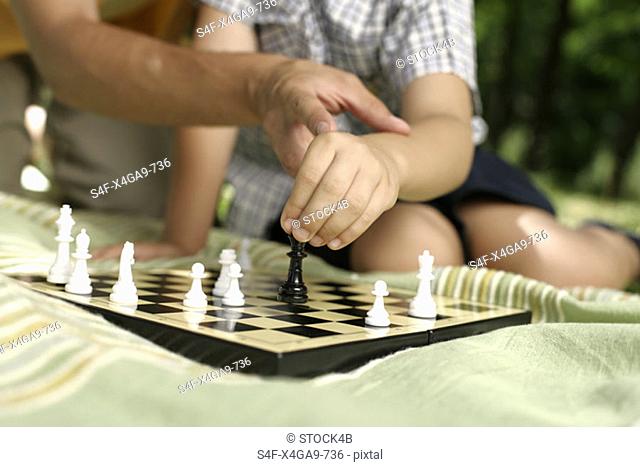 Father teaching son in chess