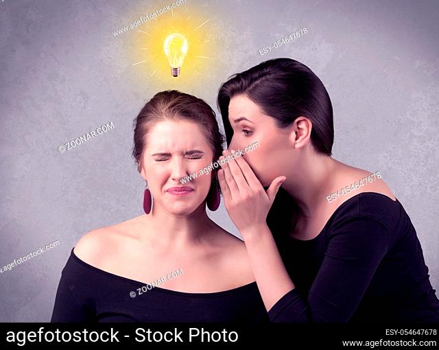 A young girl has an idea illustrated with a drawn glowing light bulb above the head, while a friend whispers a secret in her ear concept