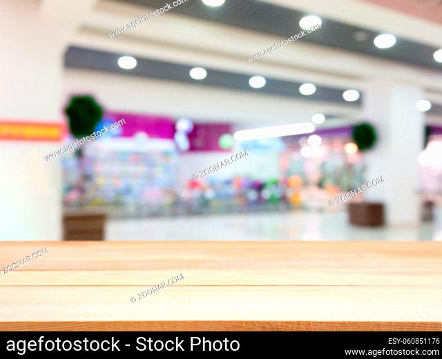 Wooden board empty table in front of blurred background. Perspective light wood table over blur in shopping mall hall. Mock up for display or montage your...