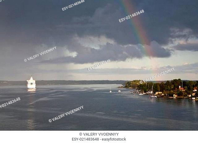 white cruise liner and rainbow