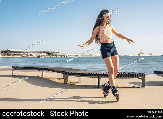 Young woman inline skating on waterfront promenade