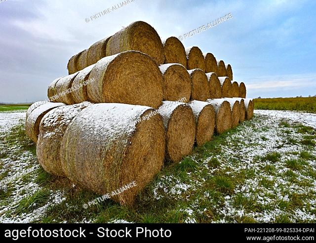08 December 2022, Brandenburg, Petersdorf: A little snow lies on straw rolls on a field in East Brandenburg. The day began with snow in Brandenburg