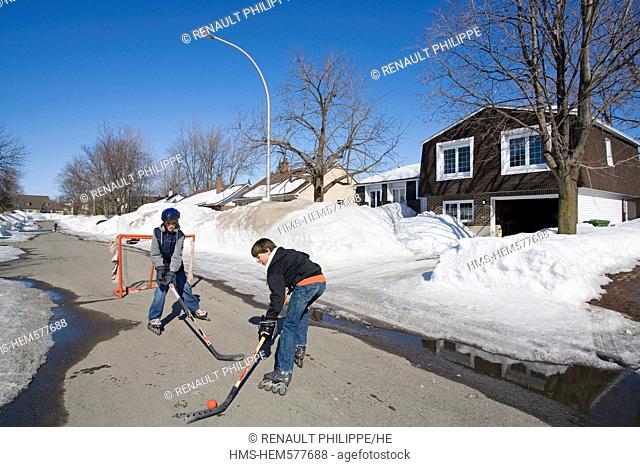Canada, Quebec province, Montreal, Laval Montreal suburb, kids playing street hockey in a residential area