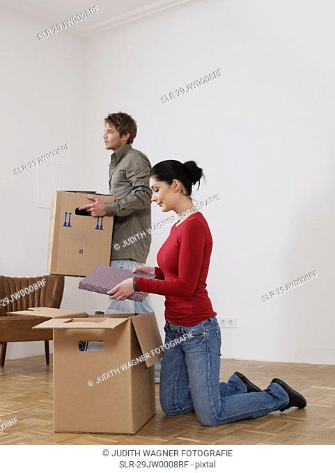 Women unpacks while man helps