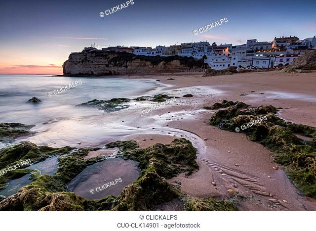 Sunset on the village perched on the promontory overlooking the beach of Carvoeiro, Lagoa Municipality, Algarve, Portugal Europe