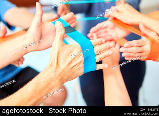 Hände machen Übung mit dem Elastikband als Physiotherapie in der Reha