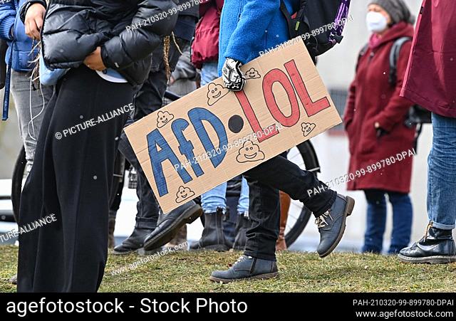 20 March 2021, Brandenburg, Frankfurt (Oder): A participant with a sign reading ""AfD LOL"" (LOL: is an acronym for Laughing Out Loud) protests against the...