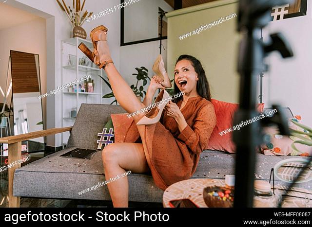 Woman showing high heels while vlogging at home