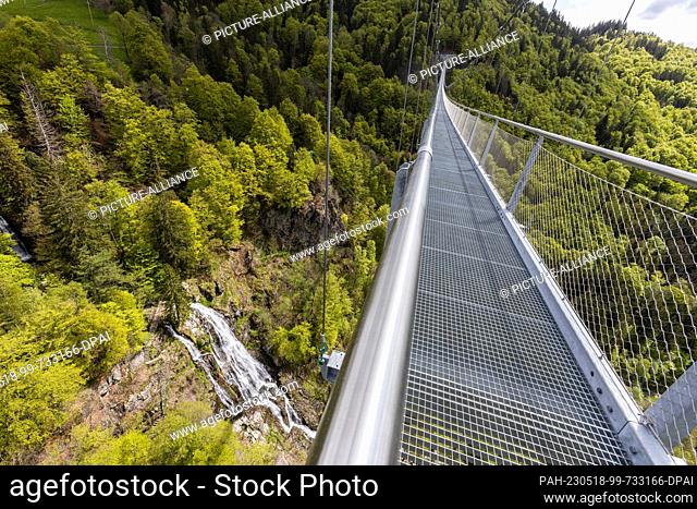 17 May 2023, Baden-Württemberg, Todtnau: A suspension bridge leads over a valley near Todtnauberg while below water the Todtnau waterfalls can be seen