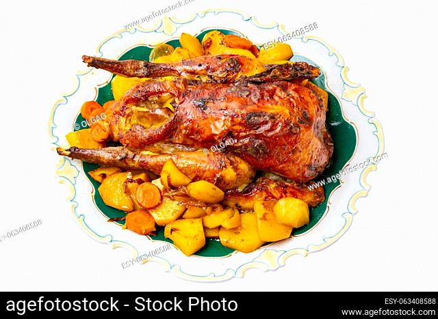 Grilled whole guinea fowl or baked pearl chicken on roasted potatoes and vegetables and port wine sauce is served on a beautiful plate. Clipping path