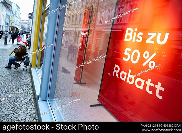 15 December 2021, Mecklenburg-Western Pomerania, Stralsund: A sign reads ""Up to 50% off"" in the window of a high street store