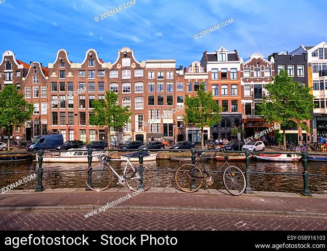 Typical buildings, canal and bikes in Amsterdam by day, Netherlands