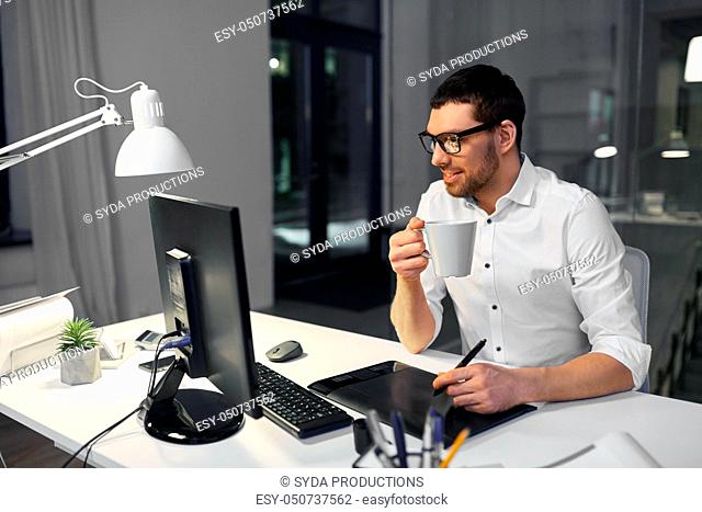 designer with pen tablet drinking coffee at office