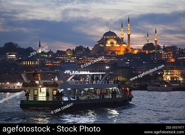 View to the Süleymaniye Mosque-Süleymaniye Camii in Fatih district on Goldenhorn with daily excursions boats in the foreground by night, Istanbul