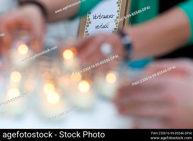 16 June 2023, Lower Saxony, Osnabrück: Candles are lit in front of a ""Wailing Wall"" with the words ""Loss of Trust"" at a vigil on the eve of the Ecumenical...