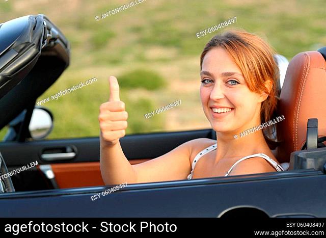 Happy car driver looking at camera gesturing thumbs up