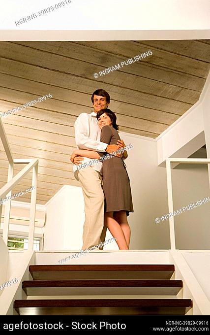 Couple hugging at top of stairs