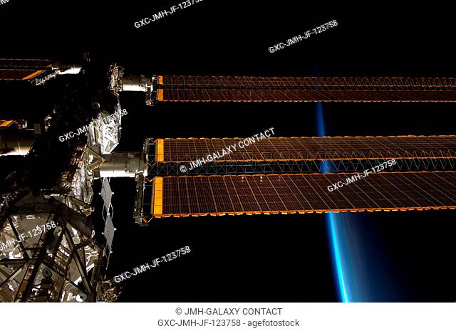 Backdropped by the thin line of Earth's atmosphere and the blackness of space, a portion of the International Space Station is featured in this image...