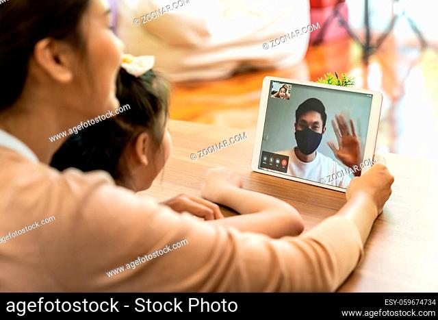 Quarantine father video conference call with his family of mom and daughter while stay in state quaratine. Technology and family reunion new normal while...