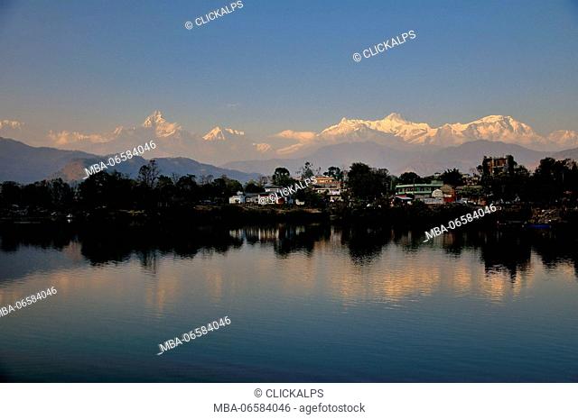 The major peaks of Annapurna is reflected in the lake at sunset in Pokhara, Nepal